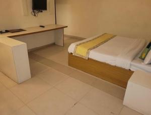 a bedroom with a bed and a desk with a television at Tulip Palms in Jaipur