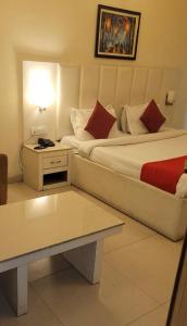 a hotel room with a large bed and a table at Tulip Palms in Jaipur
