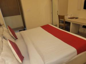a large bed in a room with a desk and a desk at Tulip Palms in Jaipur
