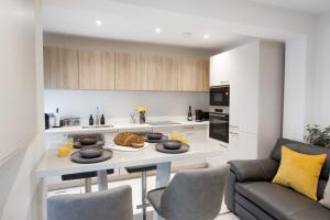 a kitchen with a table with plates of food on it at Central Cheltenham Luxury Apartment – Edmonstone House in Cheltenham