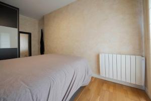 a bedroom with a white bed and a radiator at Villas del Empereur in Hendaye