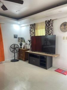 a living room with a large flat screen tv at HUBIBI Villa Staycation Balayan in Sepaco