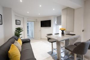a living room with a couch and a table at Central Cheltenham Luxury Apartment – Edmonstone House in Cheltenham +30 photos