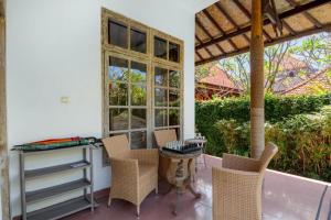 a patio with chairs and a table and windows at Villa 3bdrm Sanur 800 m ocean in Sanur