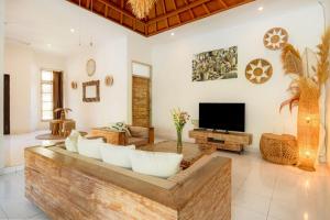 a living room with a couch and a tv at Villa 3bdrm Sanur 800 m ocean in Sanur