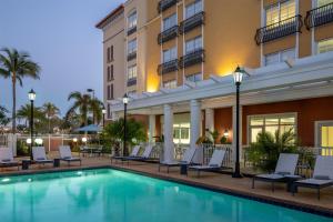 a hotel pool with lounge chairs and a hotel at Hyatt Place Fort Myers Estero - Newly Renovated in Estero