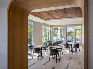 a dining room with tables and chairs and windows at Hyatt Place Fort Myers Estero - Newly Renovated in Estero