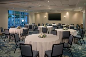a conference room with tables and chairs and a screen at Hyatt Place Fort Myers Estero - Newly Renovated in Estero