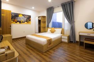 a hotel room with a bed and a desk at ROMANCE HOTEL DALAT in Da Lat
