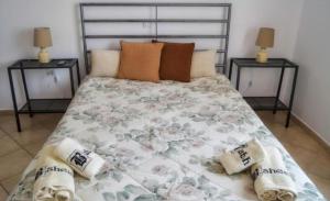 a bedroom with a large bed with two night stands at Aegina House in Egina