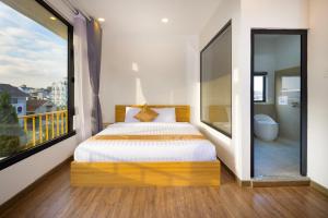 a bedroom with a bed and a large window at ROMANCE HOTEL DALAT in Da Lat