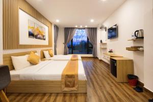 a bedroom with a large bed and a tv at ROMANCE HOTEL DALAT in Da Lat