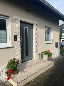 a front door of a house with two potted plants at Ferienwohnung in Staufenberg- Treis in Staufenberg