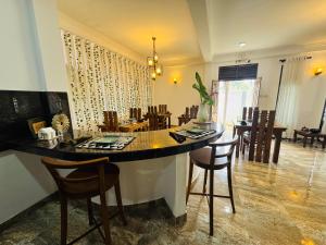a kitchen and dining room with a large island with chairs at The Green Escape in Miriswatta