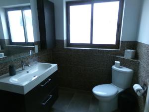 a bathroom with a toilet and a sink and two windows at Panoramic XL Penthouse Sliema Seafront in Sliema +41 photos