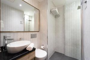 a bathroom with a sink and a toilet and a mirror at Atik Hotel Nişantaşı in Istanbul