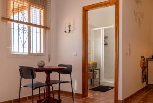 a dining room with a table and chairs and a mirror at Casa Mira in Cómpeta