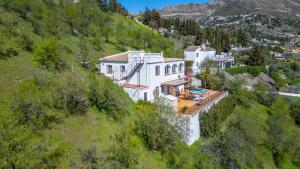a white building on a hill in the mountains at Casa Mira in Cómpeta