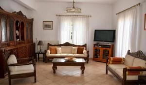 a living room filled with furniture and a tv at Aegina House in Egina