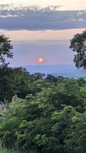 a sunset over a forest of trees with the sun in the sky at Dimora dei nonni in Poggioferro