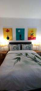 a bedroom with a bed with three paintings on the wall at Anyomi Zen in Gqeberha