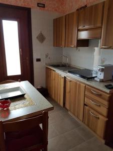 a kitchen with wooden cabinets and a counter top at Augusta Palm Apartment in Bibione