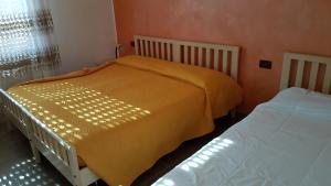 a bedroom with two beds with yellow sheets and a window at Augusta Palm Apartment in Bibione