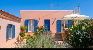 a house with blue shutters and stairs in front at Aegina House in Egina