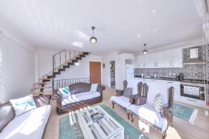 a living room with two couches and a staircase at Villa Mars in Kaş