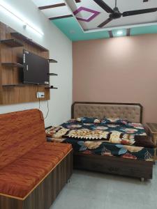 a bedroom with a bed and a flat screen tv at Janki Guest House in New Delhi
