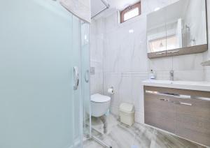 a white bathroom with a toilet and a sink at Villa Mars in Kaş