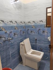 a bathroom with a dolphin mural on the wall at Janki Guest House in New Delhi