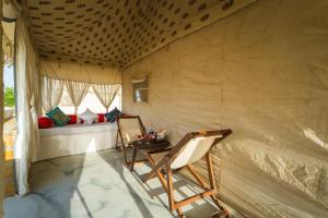 a room with a table and chairs in a tent at Jumeria Grand Luxury Desert Resort & Camp in Jaisalmer