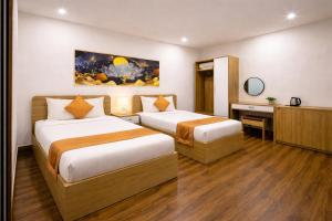 a hotel room with two beds and a desk at ROMANCE HOTEL DALAT in Da Lat