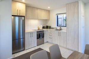 a kitchen with wooden cabinets and a stainless steel refrigerator at Charming 2-Bedroom Apartment - 2 BR, 1 Bath in Christchurch