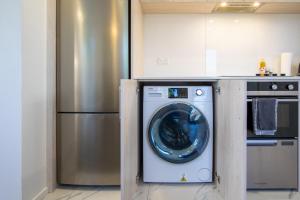 a washing machine in a kitchen next to a refrigerator at Charming 2-Bedroom Apartment - 2 BR, 1 Bath in Christchurch +14 photos
