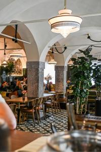 a restaurant with tables and chairs and people sitting at tables at ROYAL ROOMS*** in Ljubljana