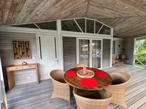 a wooden table and chairs on a deck at FARE VAVAE in Tevaitoa