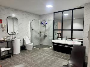 a bathroom with a shower and a tub and a toilet at Glory House in An Khê +22 photos