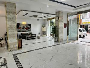 a lobby with a couch and a clock on the wall at Glory House in An Khê