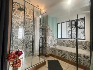 a bathroom with a shower and a tub at Le Cosy 8km du futuroscope in Beaumont