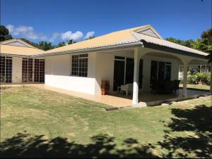 a house with a porch and a lawn at Mirimiri guest house in Tahu-Naoe