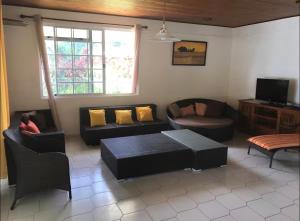a living room with a couch and a table at Mirimiri guest house in Tahu-Naoe