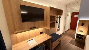 a room with a flat screen tv on a wall at Hotel Antares München in Munich