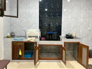 a kitchen with a sink and a counter top at Cocoon Casa in Hat Yai