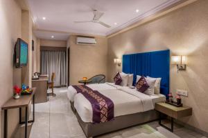 a bedroom with a large bed with a blue headboard at Lords Eco Inn Dahej in Dahej +33 photos