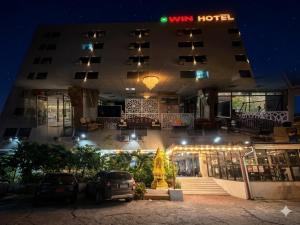 a hotel with cars parked in front of it at night at Win Mansion in Bangkok