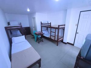 a room with two beds and a table and a chair at JRJ Lodge in San Carlos