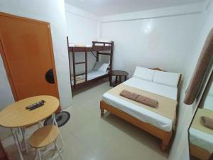 a bedroom with a bed and a table and a desk at JRJ Lodge in San Carlos