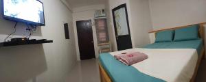 a small bedroom with a bed with a television on the wall at JRJ Lodge in San Carlos
